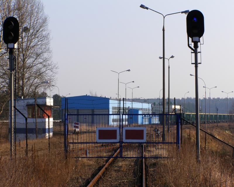 fot. nieznany 
Brama wjazdowa do Zakładu Gospodarki Cysternami Słotwiny GATX Rail Poland Sp. z o.o., widok od strony stacji Słotwiny. Warsztaty nieużytkowane, tankowanie cystern od dawna nie wykonywane, obie zakładowe nastawnie z braku ruchu nie funkcjonują. Obraz