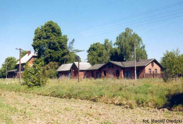 fot. Maciej Olędzki 
Zabudowania stacyjne od strony peronów; w centrum kadru budynek mieszkalny, z lewej dworzec. W lewo Pruszcz Bagienica, w prawo Terespol Pomorski. Obraz