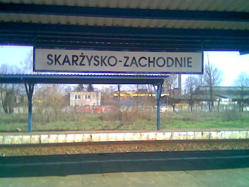 fot. Many 
Skarżysko-Zachodnie, peron 1 z tablicą z nazwą przystanku. W tle peron 2 i zakłady Mesko. W lewo stacja Skarżysko-Kamienna, w prawo Radom. Obraz
