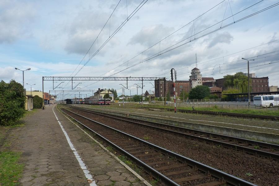 fot. Roman Paul 
Ogólny widok na perony wschodnie (1 i 2) od strony wjazdu z Bojanowa/Wrocławia; wschodnia strona dworca. W tle, po prawej, potężna bryła leszczyńskiego młyna stojącego przy ul. Przemysłowej. Kierunek północny (Wolsztyn, Kąkolewo, Kościan/Poznań). Obraz