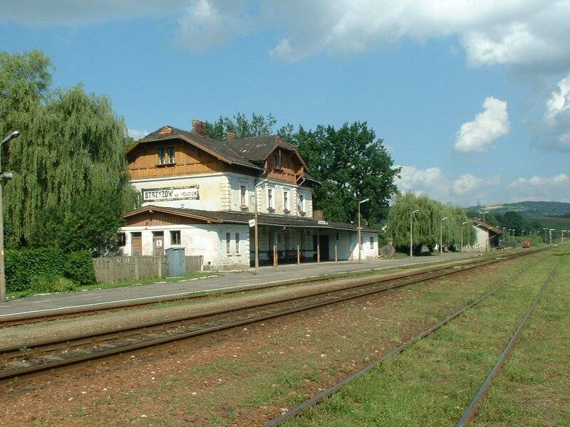 fot. Piotr T 
Strzyżów nad Wisłokiem. Budynek dworca. W tle nieużywany magazyn i semafory wyjazdowe w kierunku Rzeszowa. Widok od strony Jasła. Obraz