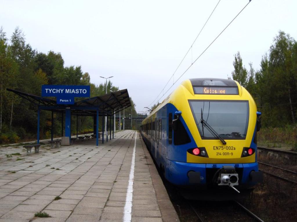 fot. D. Wójcik 
Tychy Miasto. Flirt oczekuje na odjazd do Katowic na peronie 1. W tle czynna kładka dla pieszych prowadząca do miasta. Widok w kierunku stacji Tychy/Katowic. Obraz