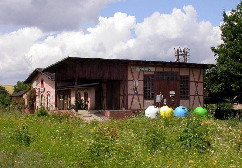 fot. nieznany 
Budynek dworca i magazyn towarowy z rampą od strony peronu. Widok w kierunku północnym, od strony wjazdu z Marciszowa. Obraz