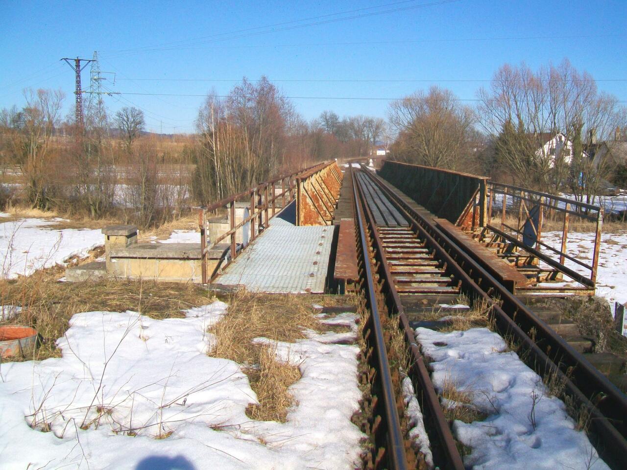 fot. wasiukibic 
Czteroprzęsłowy most kolejowy nad ul. Asnyka i ciekiem Żywica. Filary są przygotowane pod montaż drugiego toru. Widok w kierunku północno-wschodnim (Kamienna Góra) z przyczółka od strony Lubawki. Obraz