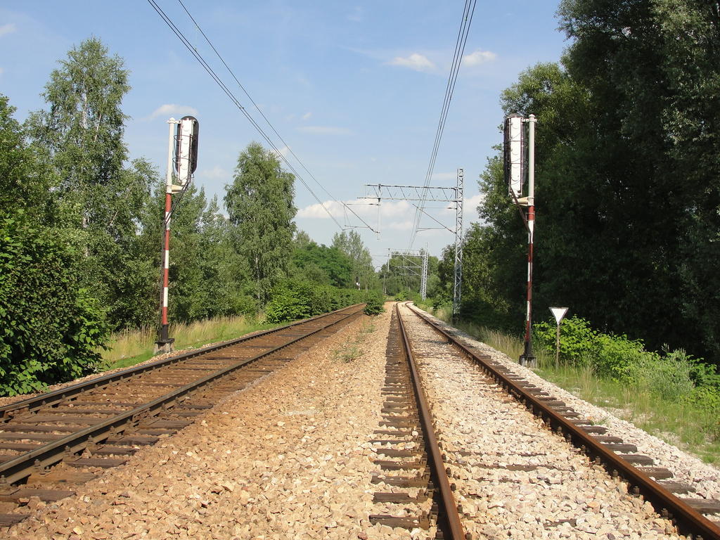 fot. Kamil 
Widok w stronę Katowic Muchowca, po lewej linia p.odg Szadok (Kolej piaskowa) - p.odg Panewnik. W tle semafory wjazdowe na p.odg Panewnik oraz w oddali semafor wjazdowy na p.odg Szadok. Obraz