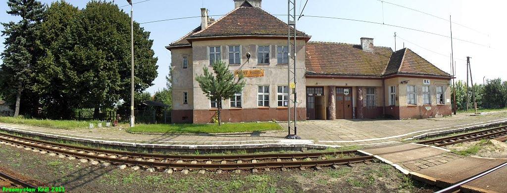 fot. Przemysław Król 
Budynek dworca od strony peronów. Na parterze mieści się nastawnia dysponująca. W lewo Zduńska Wola, w prawo Chorzew Siemkowice. Obraz