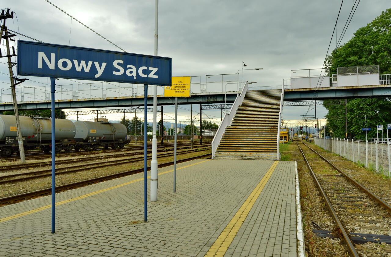 fot. Tomasz 
Nowy Sącz, widok z peronu 2 w kierunku Muszyny i Chabówki (południowy-zachód). Kładka łączy peron 1 (z prawej) z NEWAGiem (w lewo) - dawny ZNTK Nowy Sącz. Obraz