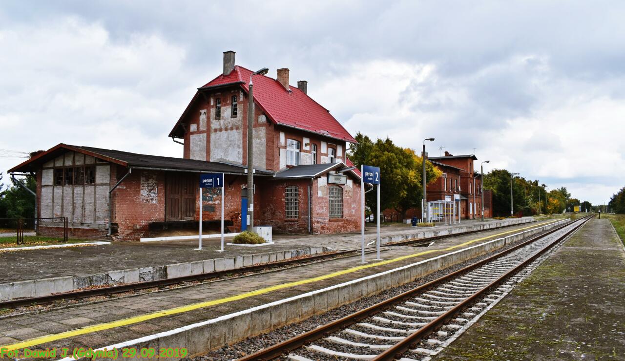 fot. Dawid Jastrzębski 
Widok z peronu 3 w kierunku Laskowic Pomorskich/Działdowa. Budynek dworcowy z przyległą przybudówką po nastawni i przyległym budynkiem magazynu oraz kolejowe budynki mieszkalne (ul. Dworcowa 5 i 3), znajdują się po lewej stronie. Obraz