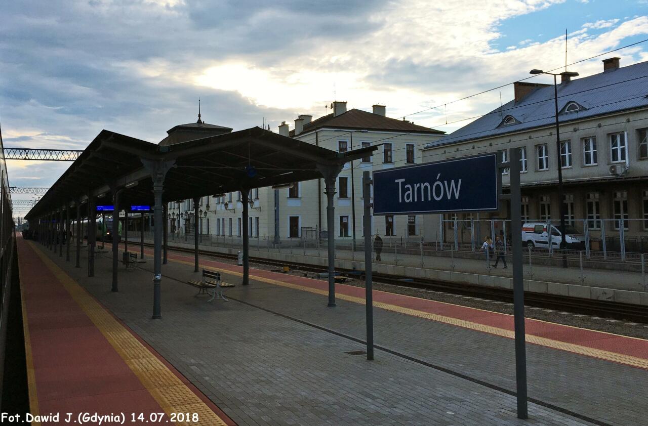 fot. Dawid Jastrzębski 
Widok z peronu 1 w kierunku Bochni/Krakowa Głównego i Szczucina koło Tarnowa. Wiata na peronie. Tablica z nazwą stacji. Budynek dworcowy znajduje się po prawej stronie. Obraz