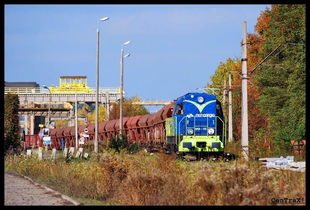 fot. Damian Stupień 
Trumna manewruje z ładownymi szutrówkami, w tle brama zakładu. Słupy po prawej to linia 144 w kierunku Tworoga. Obraz