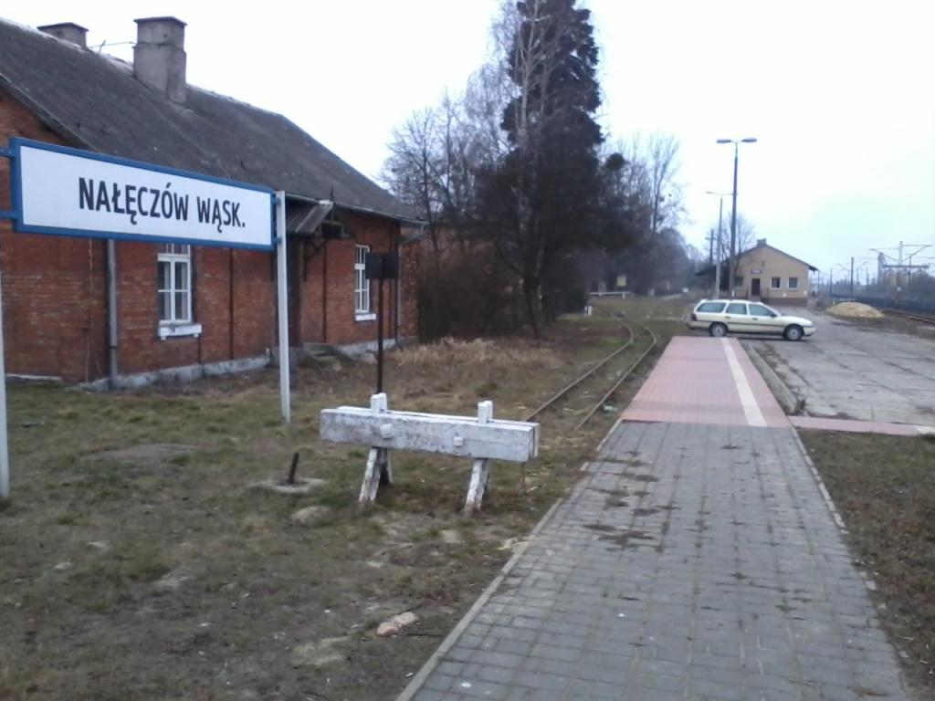 fot. Adrian Chromik 
Mały peronik stacyjki Nałęczów Wąskotorowy i kozioł oporowy Nałęczowskiej Kolei Wąskotorowej. Po lewej jakiś budynek z czerwonej cegły, a po prawej linia normalnotorowa nr 7. Widok w kierunku Łopatek, Puław, Dęblina, Warszawy, Wąwolnicy, Opola Lubelskiego, Poniatowej i Wilkowa. Obraz