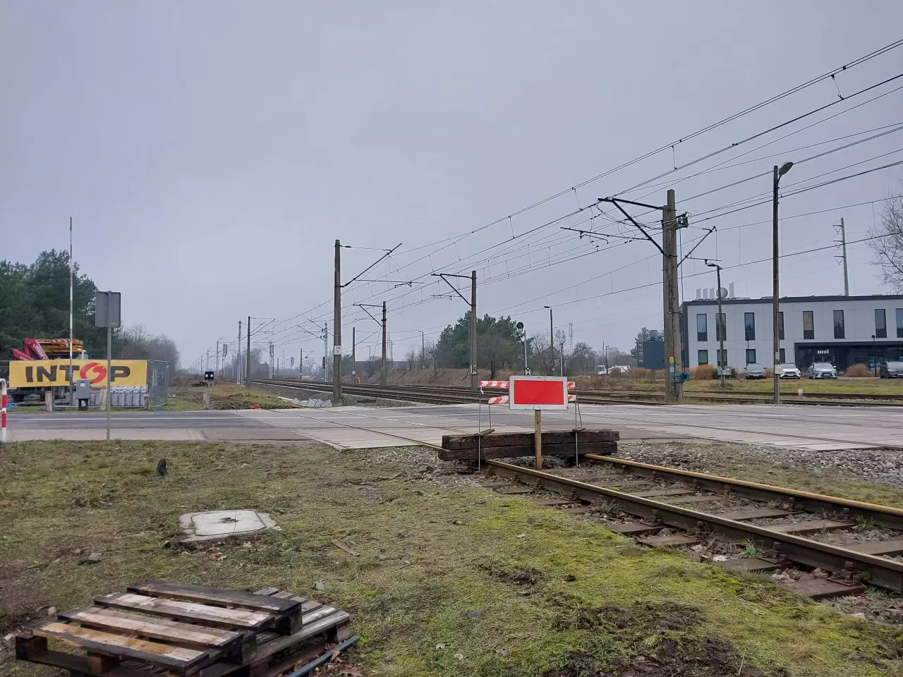 fot. Aleksander 
Prace modernizacyjne obwodnicy towarowej Poznania powoli postępują. Ostatnio rozebrano w większości tor wyciągowy z bocznicy kombinatu betoniarskiego na stacji Poznań Piątkowo. Na pozostawionym fragmencie, sięgającym do przejazdu kolejowego przy nastawni, mieści się obecnie lokomotywa manewrowa z 3 wagonami 4-osiowymi. Tor jest zabezpieczony widocznym prowizorycznym zakończeniem z podkładów i wykolejnicą za płytą przejazdu, na wypadek ewentualnego zbiegnięcia taboru. Dalej tor został zdemontowany, a wszystko to w związku z przewidywaną budową odnogi do przystanku Poznań Strzeszyn, która ma przebiegać w śladzie wspomnianego toru i dalej odbijać w lewo. Obraz